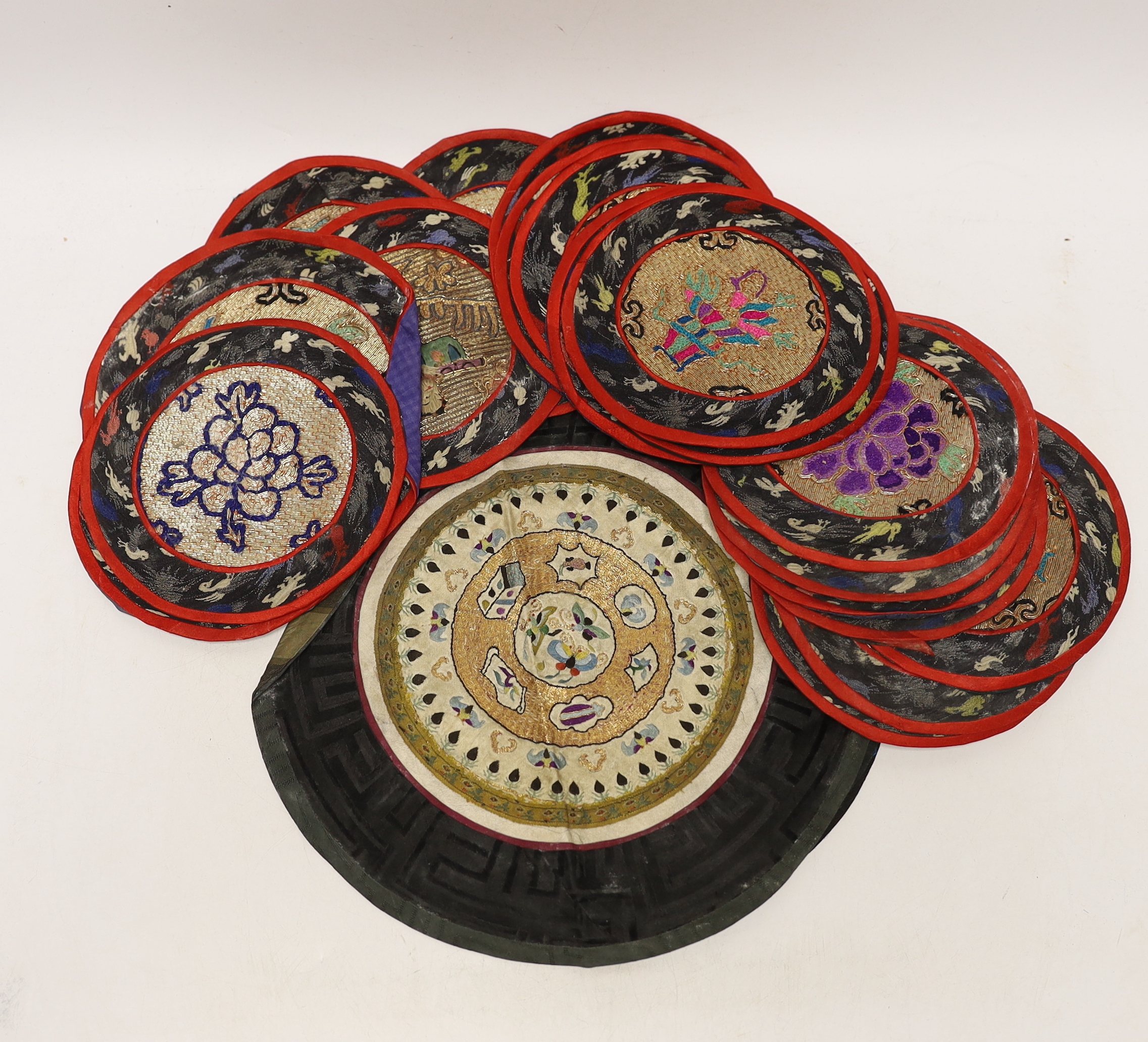 Three sets of six circular Chinese polychrome and gilt thread embroidered mats, a set of four mats and seven other similar various sized embroidered mats, (29)